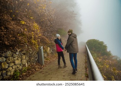 Couple walking on the foggy road through woods - Powered by Shutterstock