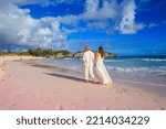 Couple walking on the Horseshoe Bay Beach in Bermuda, famous for its pink sand
