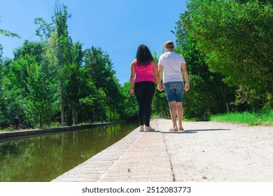 Couple walking on a path in the park. Back view. - Powered by Shutterstock