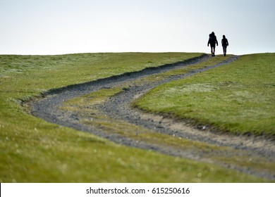 Couple Walking On The South Downs Way In Sussex