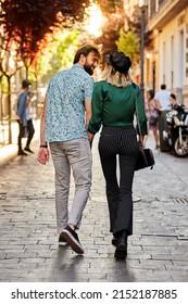 Couple Walking On Street Away From Camera.