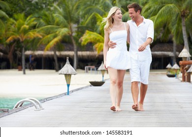 Couple Walking On Wooden Jetty