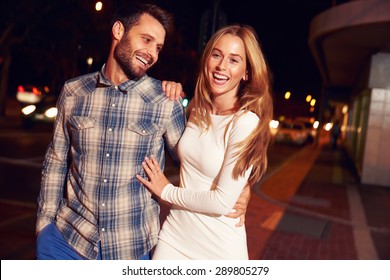 Couple Walking Through Town Together At Night