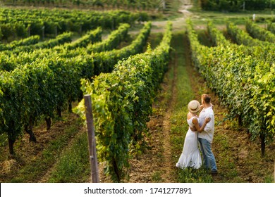 The couple walks among the green vineyard in Italy. Sunny day. - Powered by Shutterstock