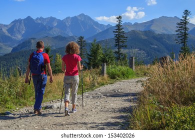A couple walks a path to the mountains in Tatra National Park, Poland