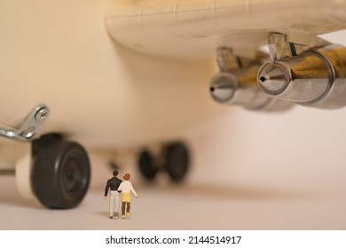 A Couple Walks Under A Huge Airplane, Rear View