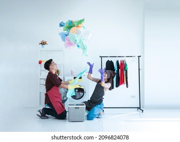 Couple Washing Clothes In The Laundry Room