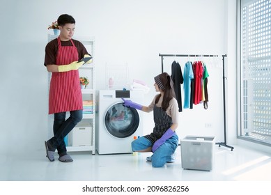 Couple Washing Clothes In The Laundry Room