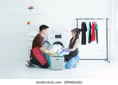 Couple Washing Clothes In The Laundry Room