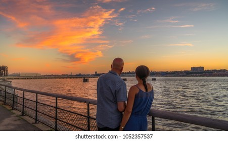 Couple Watching Beautiful Sunset At Riverside Park, Manhattan NY