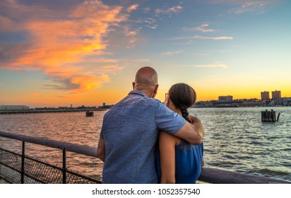 Couple Watching Beautiful Sunset At Riverside Park, Manhattan NY