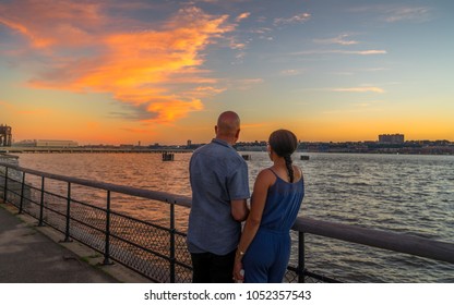 Couple Watching Beautiful Sunset At Riverside Park, Manhattan NY