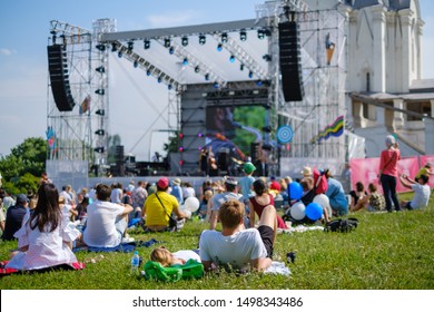 Couple Watching Concert At Open Air Music Festival, Back View, Stage And Spectators At Background