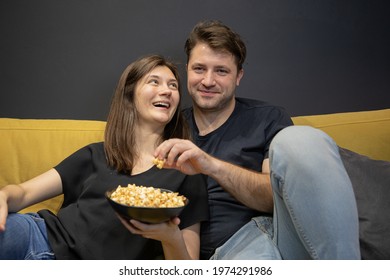 Couple Watching Funny Tv Movie Laughing Lying On Couch With Popcorn Together. Girlfriend And Boyfriend Watch Love Story, Investigation, Thriller On YouTube Channel. Young Family Evening Entertainment