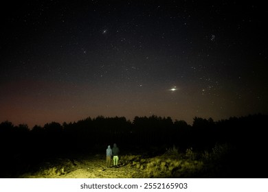 Couple watching meteor showe on a starry night in Poalnd - Powered by Shutterstock