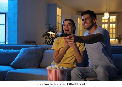 Couple Watching Movie With Popcorn On Sofa At Night, Space For Text