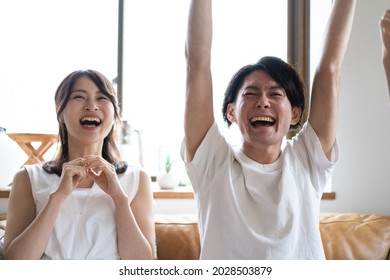 A Couple Watching A Sports Game At Home