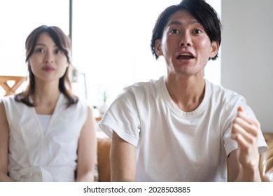 A Couple Watching A Sports Game At Home