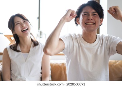 A Couple Watching A Sports Game At Home