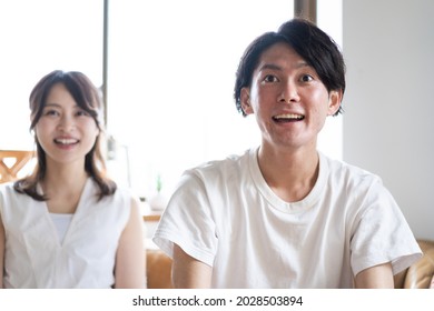 A Couple Watching A Sports Game At Home