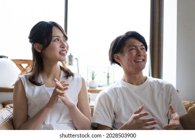 A Couple Watching A Sports Game At Home