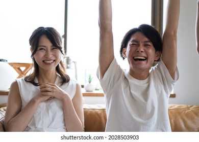 A Couple Watching A Sports Game At Home