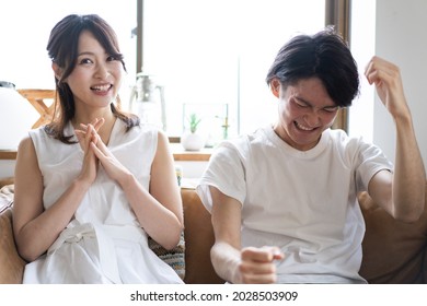 A Couple Watching A Sports Game At Home