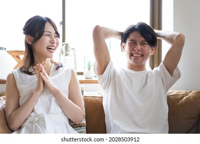 A Couple Watching A Sports Game At Home