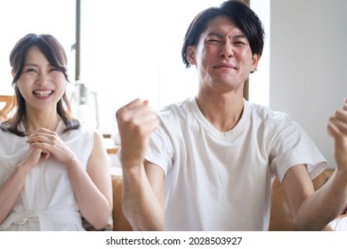 A Couple Watching A Sports Game At Home