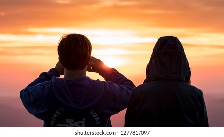 A Couple Watching The Sunrise From Mount Warning In NSW Australia