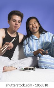 Couple Watching TV And Eating Over Blue Background