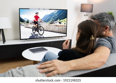 Couple Watching TV Movie On Screen In Room On Couch