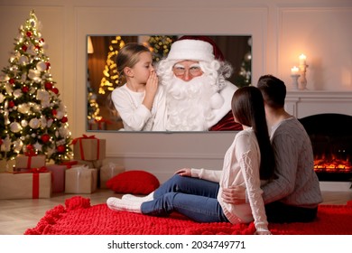 Couple Watching TV Movie In Room Decorated For Christmas