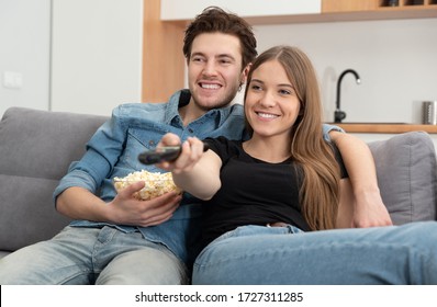 Couple watching TV on sofa. Television, multimedia, leisure concept