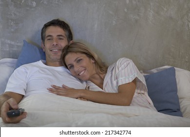 Couple Watching TV Together In Bed