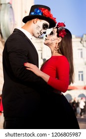 A couple, wearing skull make-up for. All souls day. Boy and girl sugar skull makeup.painted for halloween standing on the street. dead in the city. zombie walk.day of the dead holiday in mexico