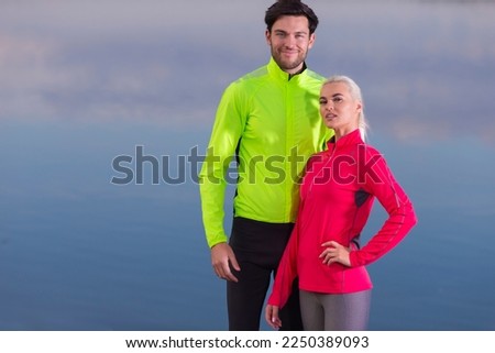 Couple While Training Outdoors on Road Near River Bank For Durable Marathon Pretty Young Female and Extremely Fit Caucasian Handsome Man in Their Prime.Horizontal Image