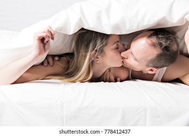 A Couple With White Duvet Over The Head