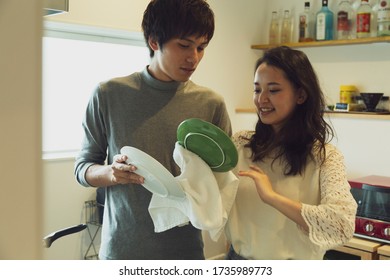 Couple wiping the dishes in the kitchen