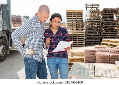 Couple Of Wokers, Man And Woman, Checking Order List At Hardware Store Warehouse