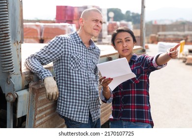 Couple Of Wokers, Man And Woman, Checking Order List At Hardware Store Warehouse