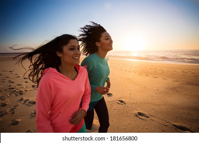 Couple of women running and walking on the beach