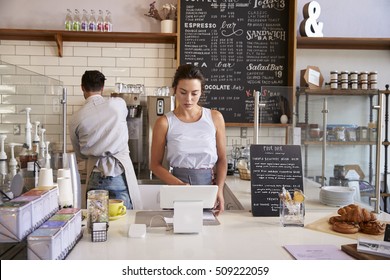 Couple working behind the counter at a coffee shop - Powered by Shutterstock