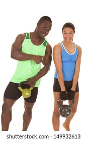 A Couple Working Out With Kettle Bells The Man Is Holding A Little Weight And She Is Working Out With The Heavier One.