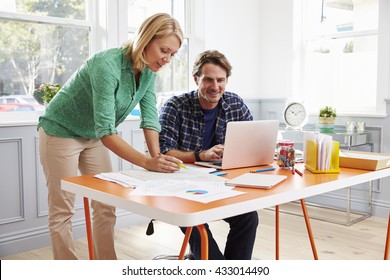 Couple Working Together At Desk In Home Office