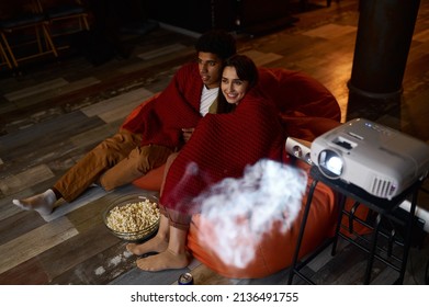 Couple Wrapped In Blanket Watching Home Projector