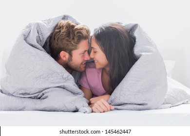 Couple Wrapped In The Duvet In Bed