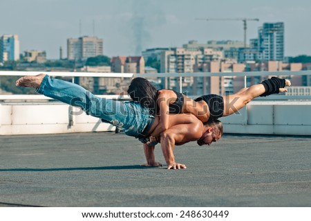 Couple yoga of woman and man on the house-top