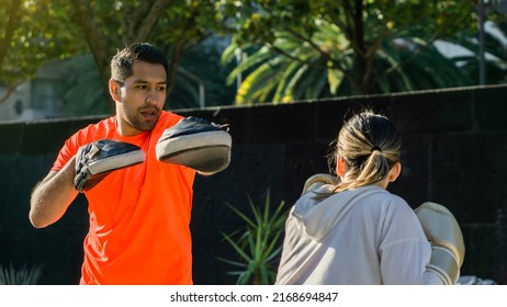 Couple Of Young Athletes Training In A Park, Street Boxing.