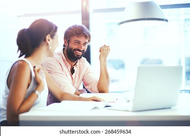 Couple Of Young Designers Working At Modern Office, Two Coworkers Discussing Fun Project Over A Laptop, Little Team Of Businesspeople Smiling And Looking Together At Computer, Students At Library